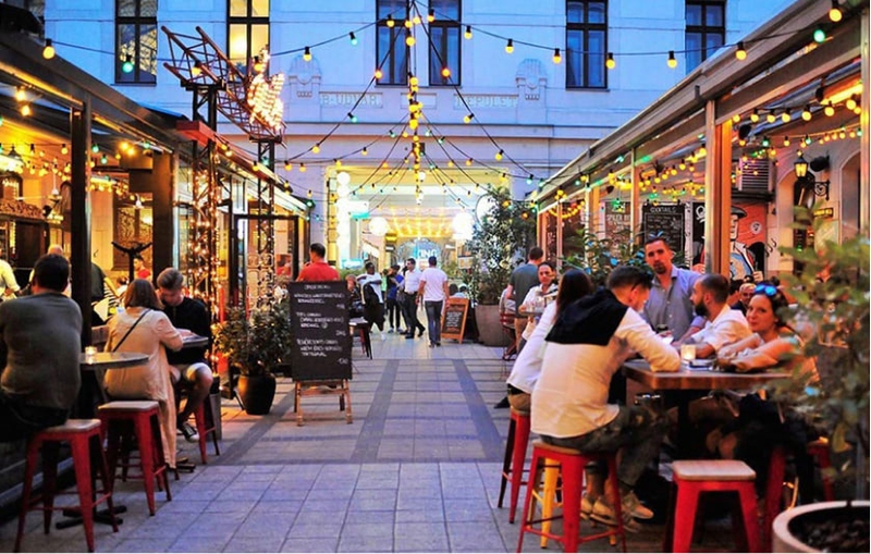 People sitting outside at the tables at night.