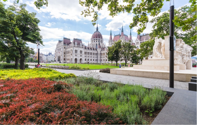 The Hungarian Parliament building and park on a sunny day.