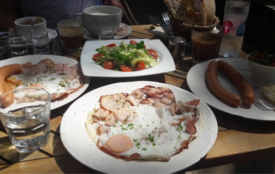 Selection of Hungarian breakfast with eggs, bacon and frankfurters.