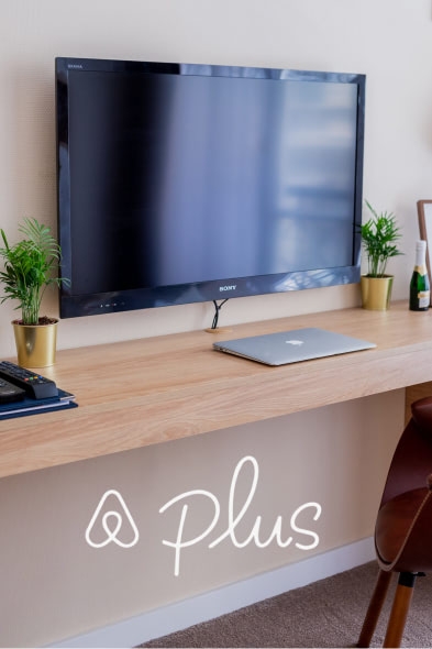 Airbnb Plus logo with the apartment's kitchen in the background.